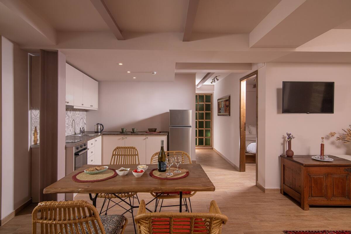 Una cocina moderna con comedor, muebles de madera y televisor de pantalla plana en la pared.