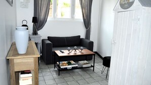 Una sala de estar pequeña y moderna con un sofá, una mesa de centro y una estantería.