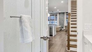 Une salle de bain moderne avec une douche à parois de verre, une serviette blanche accrochée à la porte et un carrelage décoratif.