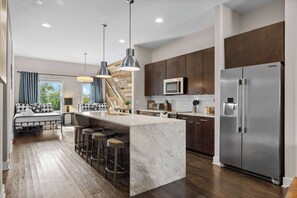 A modern kitchen with a central island, stainless steel appliances, and a dining area with a view.
