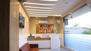 Un espace d’accueil au design moderne, comprenant un comptoir d’accueil, un coin salon et des œuvres d’art accrochées au mur.