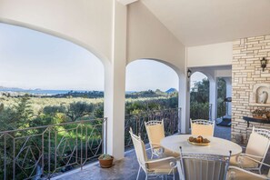 Enjoy a mountain view from this balcony with a fireplace, round table, and comfortable seating.