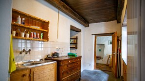 Une cuisine avec des meubles de rangement en bois, un évier et un plan de travail sur lequel se trouvent divers objets.