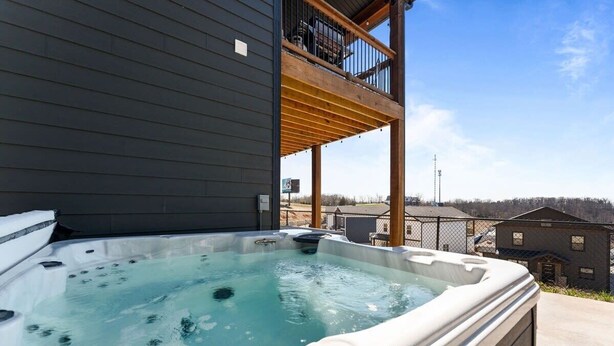 A hot tub in front of a building with a balcony.