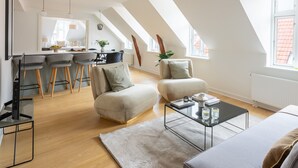 A modern loft apartment with a kitchen, dining area, and living space.