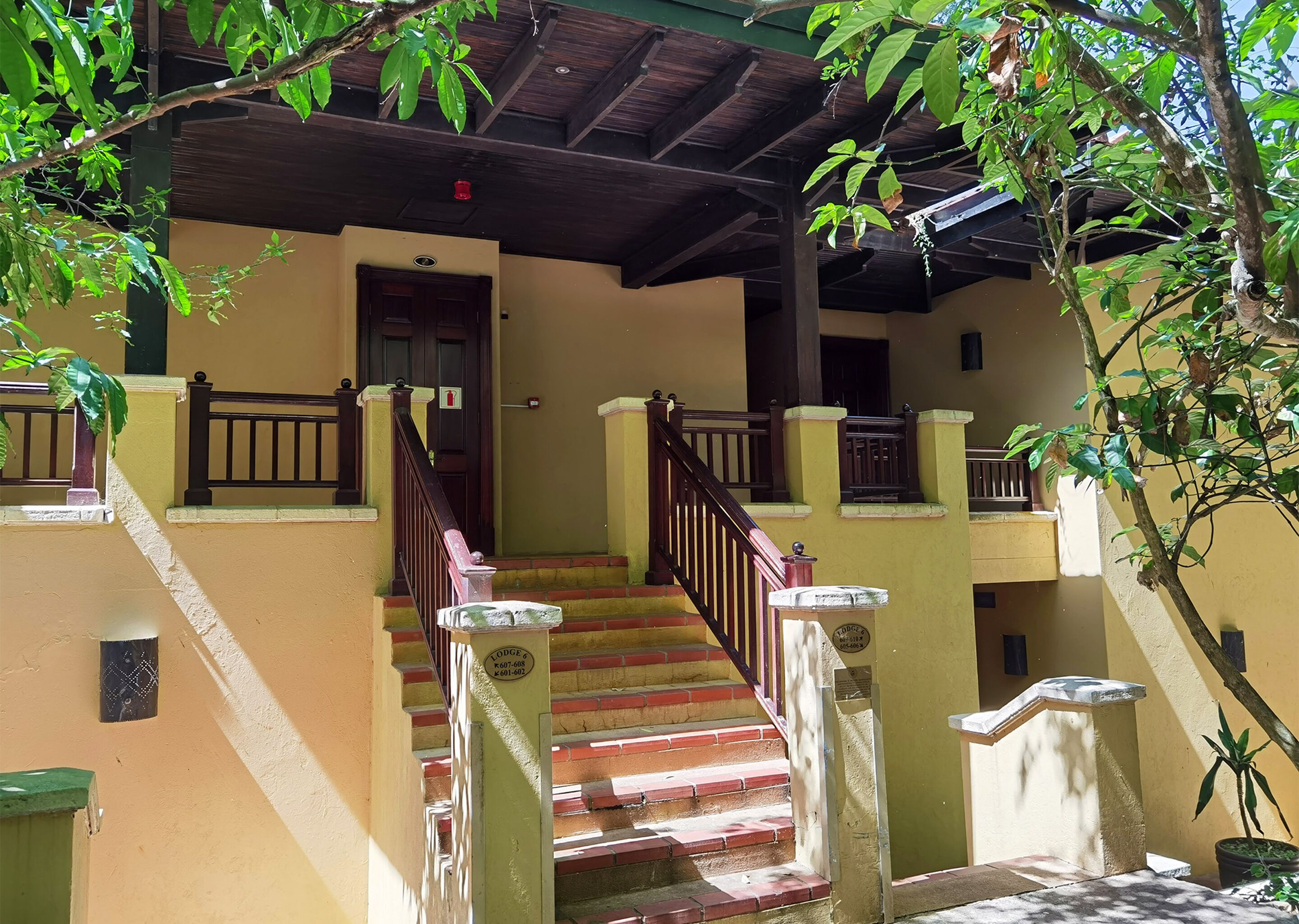 A multi-level building with a staircase, wooden railings, and a door.