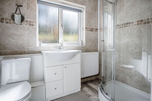 A bathroom with a toilet, sink, and shower.