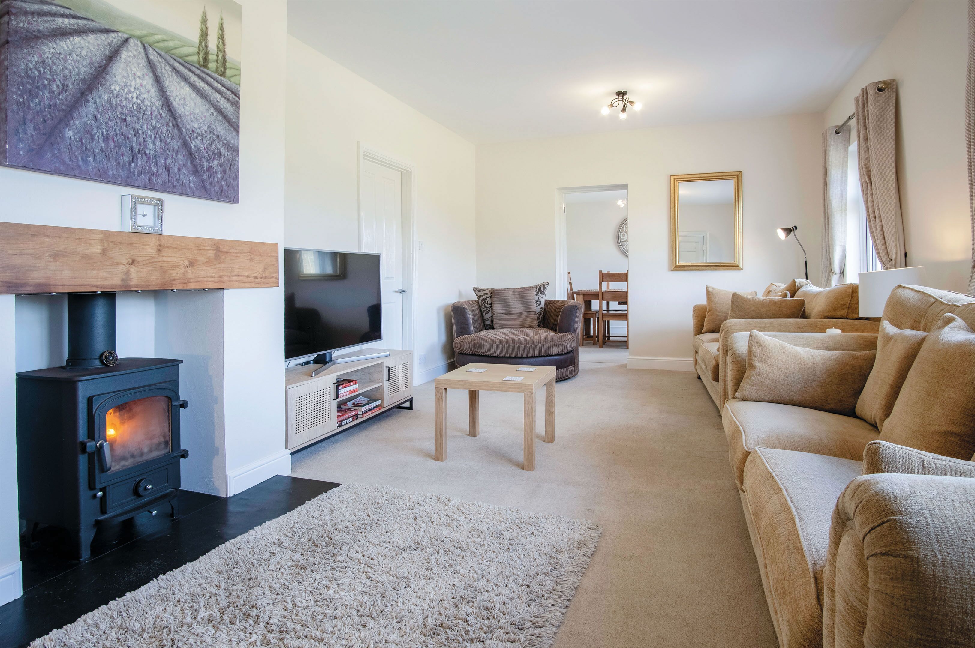 A cozy living room with a fireplace, a sofa set, a television, and a dining area.