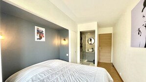 A bedroom with a bed, a bathroom with a shower, and a hallway. - Vezelay 3 (Cannes)