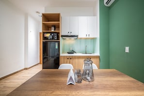 Enjoy meals in this kitchen with a dining table, stainless steel refrigerator, and coffee maker.