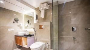 A modern bathroom with a glass-enclosed shower, a vanity with a sink, and a toilet. - Yashshree Imperial  (Siliguri)