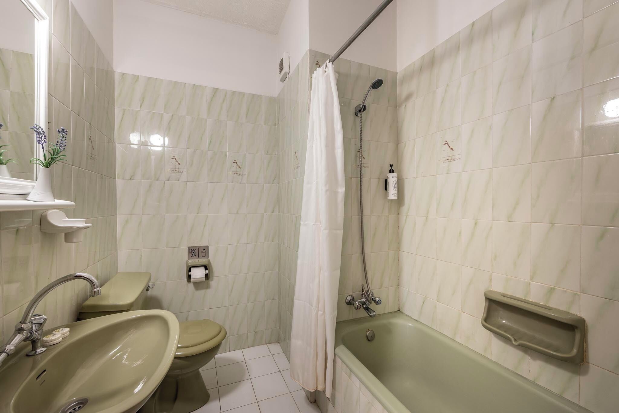 Un baño con lavamanos, inodoro y bañera.