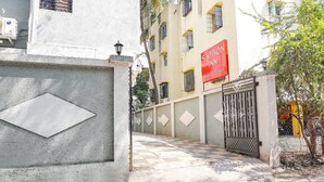 A gated entrance with a checkered pavement leading to a building with a red sign reading "SAFFRON INN."