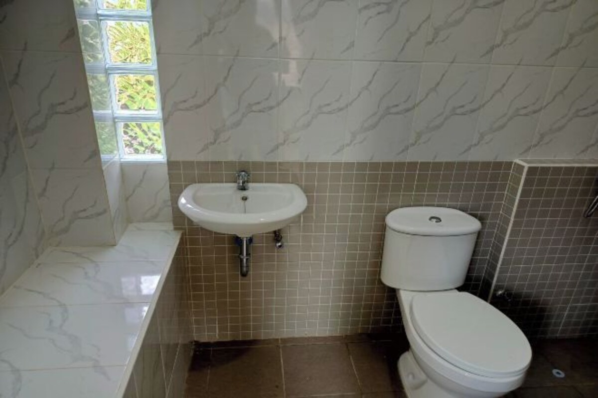 A bathroom with a white sink, a toilet, and a bathtub.