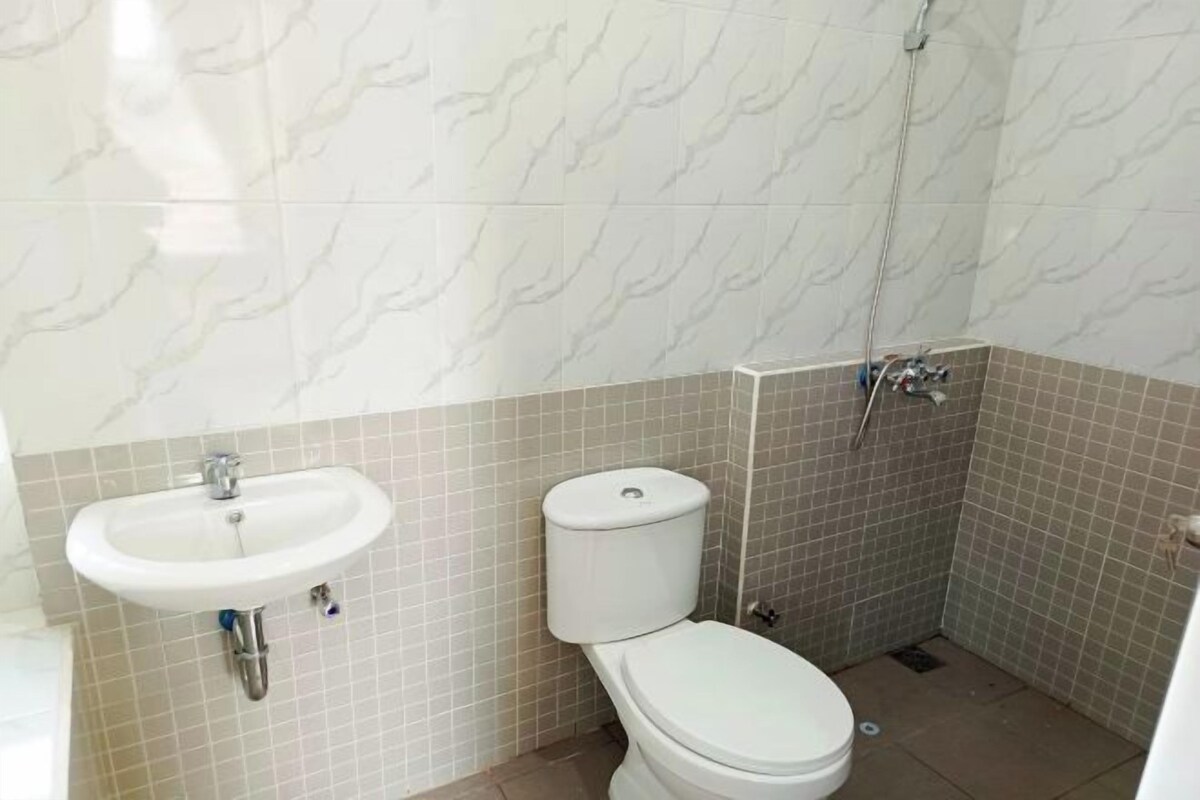A bathroom with a white sink, toilet, and shower.