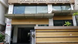 A hotel named 'Marshall The Hotel' with a modern facade, large windows, and a visible entrance.