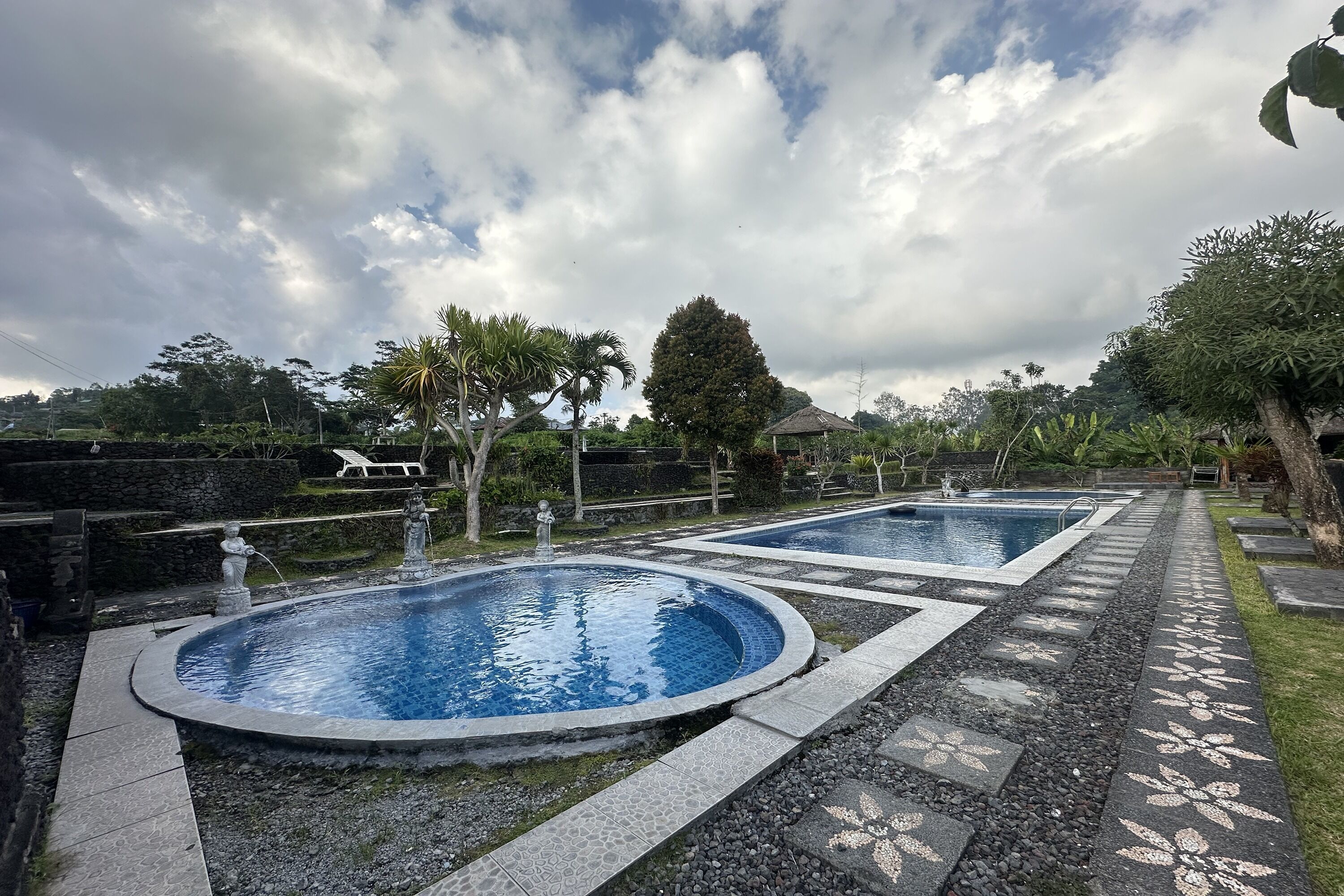 Two circular pools with a stone border and a patterned walkway.