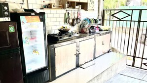 A kitchen with a refrigerator, stove, and various utensils. - Morroi Residence Kemang (Jakarta)