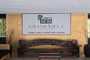 A sign for Grand Villa Laguna Resort with a palm tree logo, located at Purok 2 Brgy., Tranca, Bay, Laguna.
