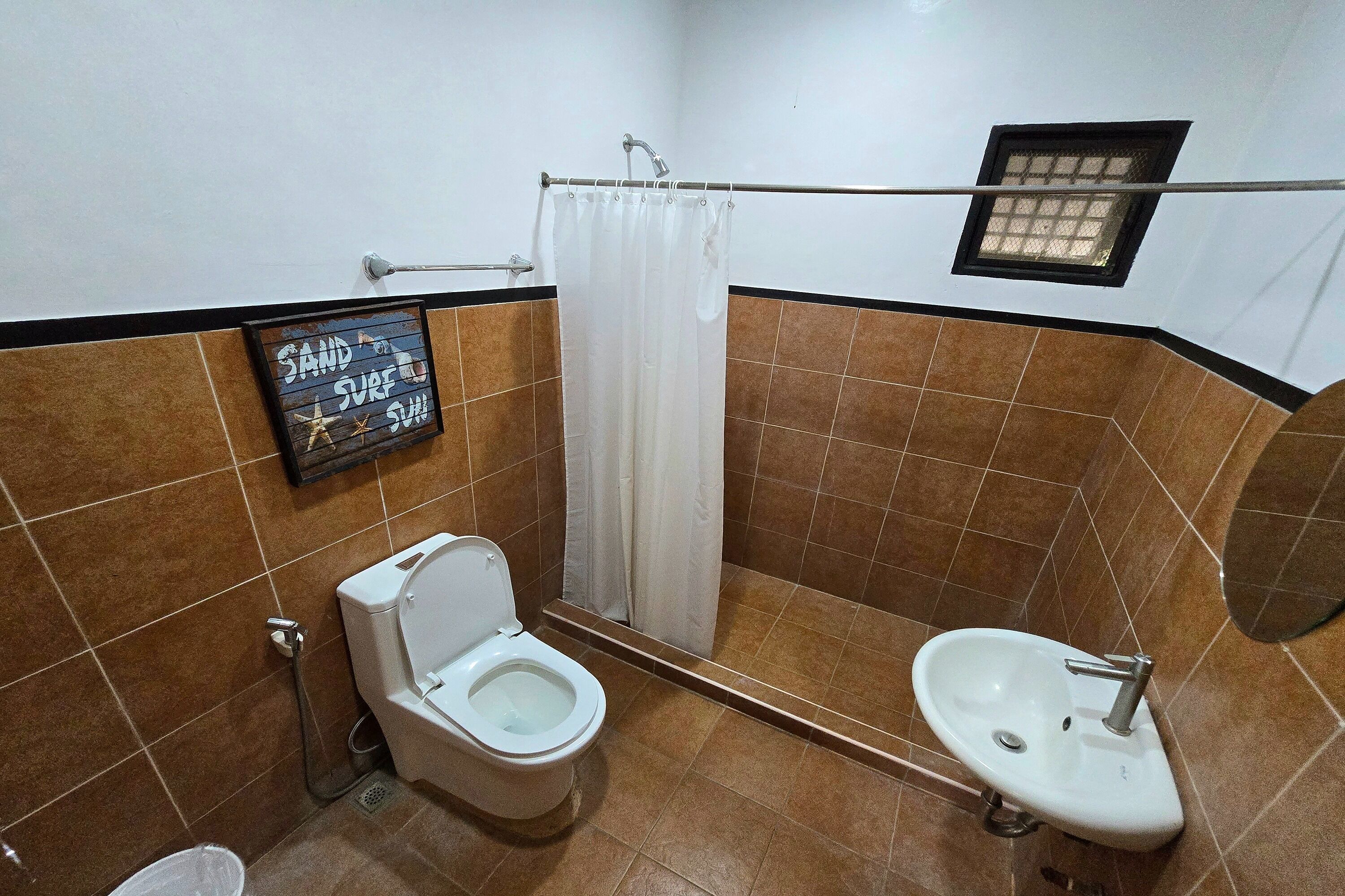 A bathroom with a toilet, a sink, and a shower curtain.