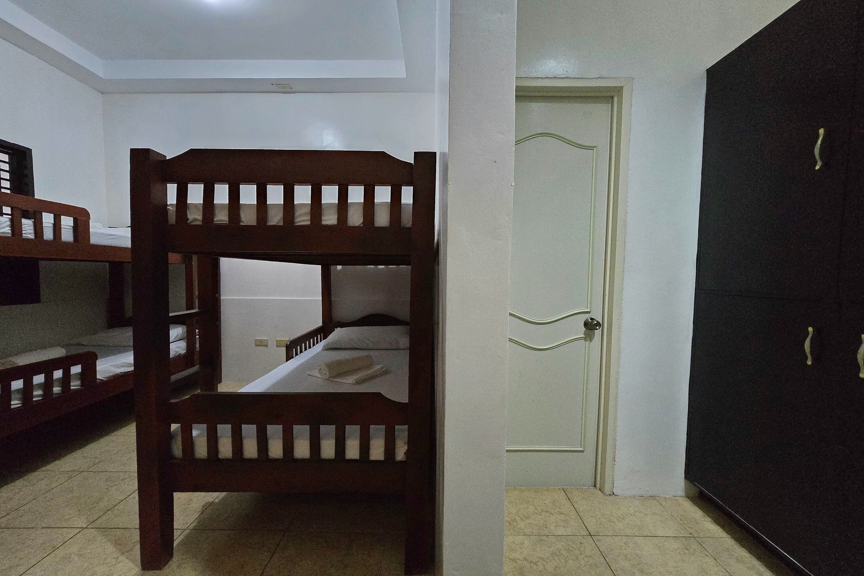 Una habitación con literas, un armario y una puerta.