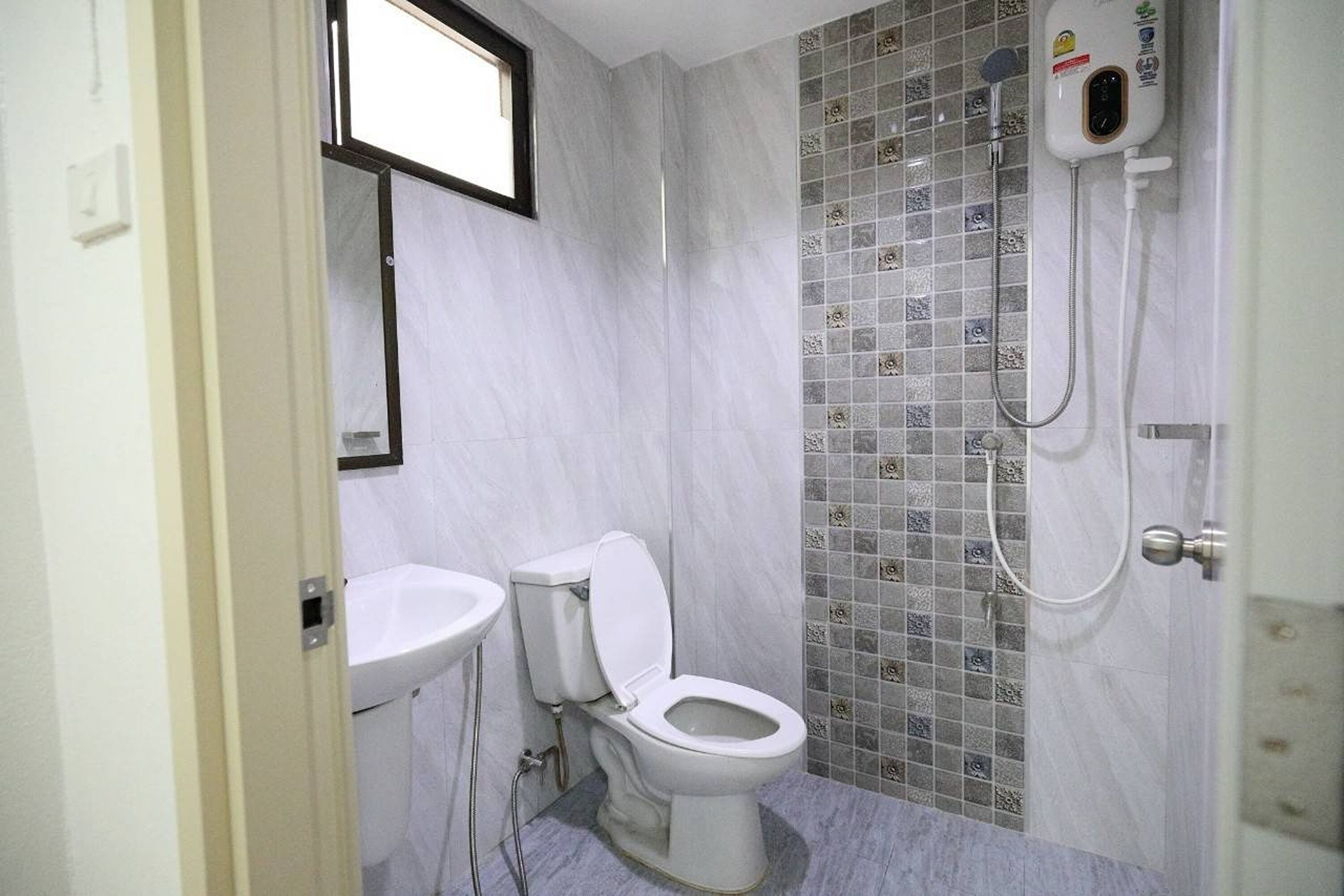 Un baño con inodoro, lavamanos y ducha.