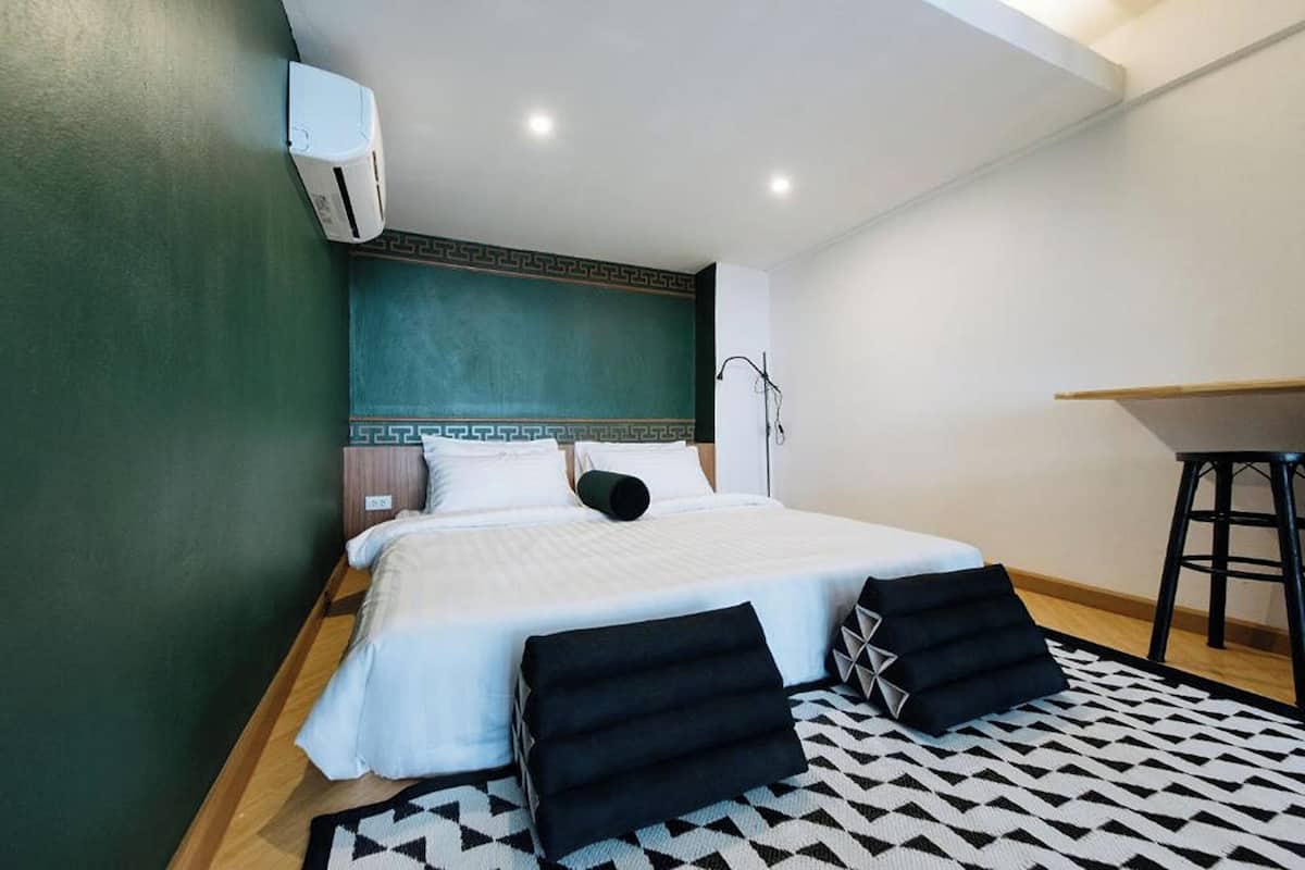 A hotel room with a bed, a desk, and a chair.