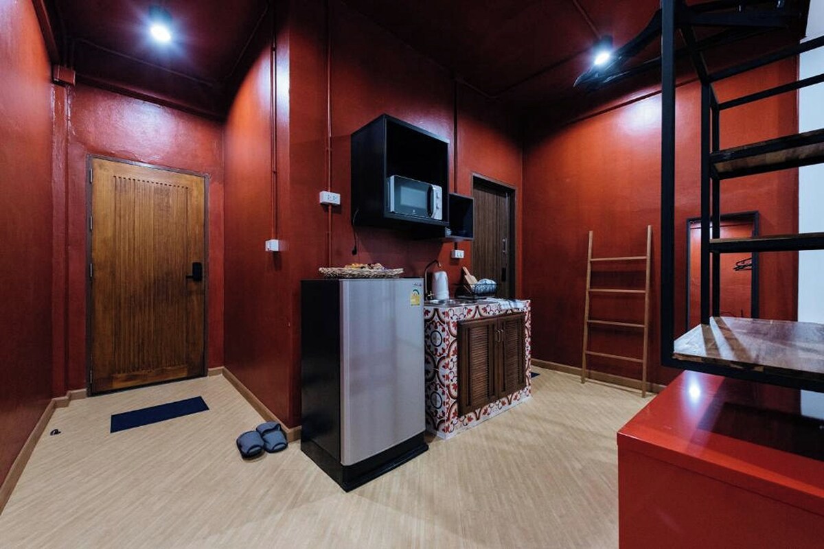 A compact kitchen with a refrigerator, microwave, and a small countertop.