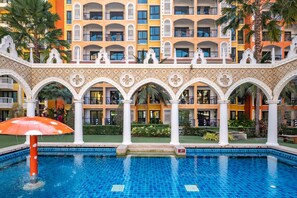 Relax by the tranquil courtyard pool surrounded by lush greenery and elegant arches.