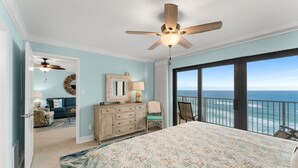 A bedroom with a bed, a dresser, a mirror, and a view of the ocean. - New Renovation, Gulf Front, Commodore 25+ (Panama City Beach)