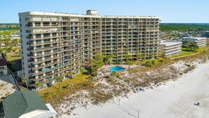 A high-rise hotel with multiple balconies, a swimming pool, and a beach view. - New Renovation, Gulf Front, Commodore 25+ (Panama City Beach)
