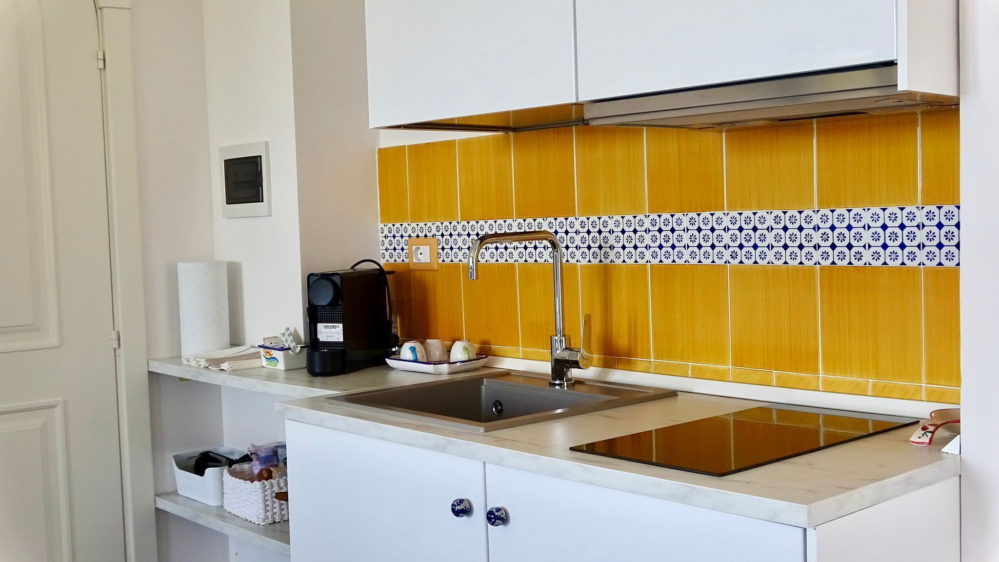 A compact kitchen with a sink, a coffee maker, and a microwave.