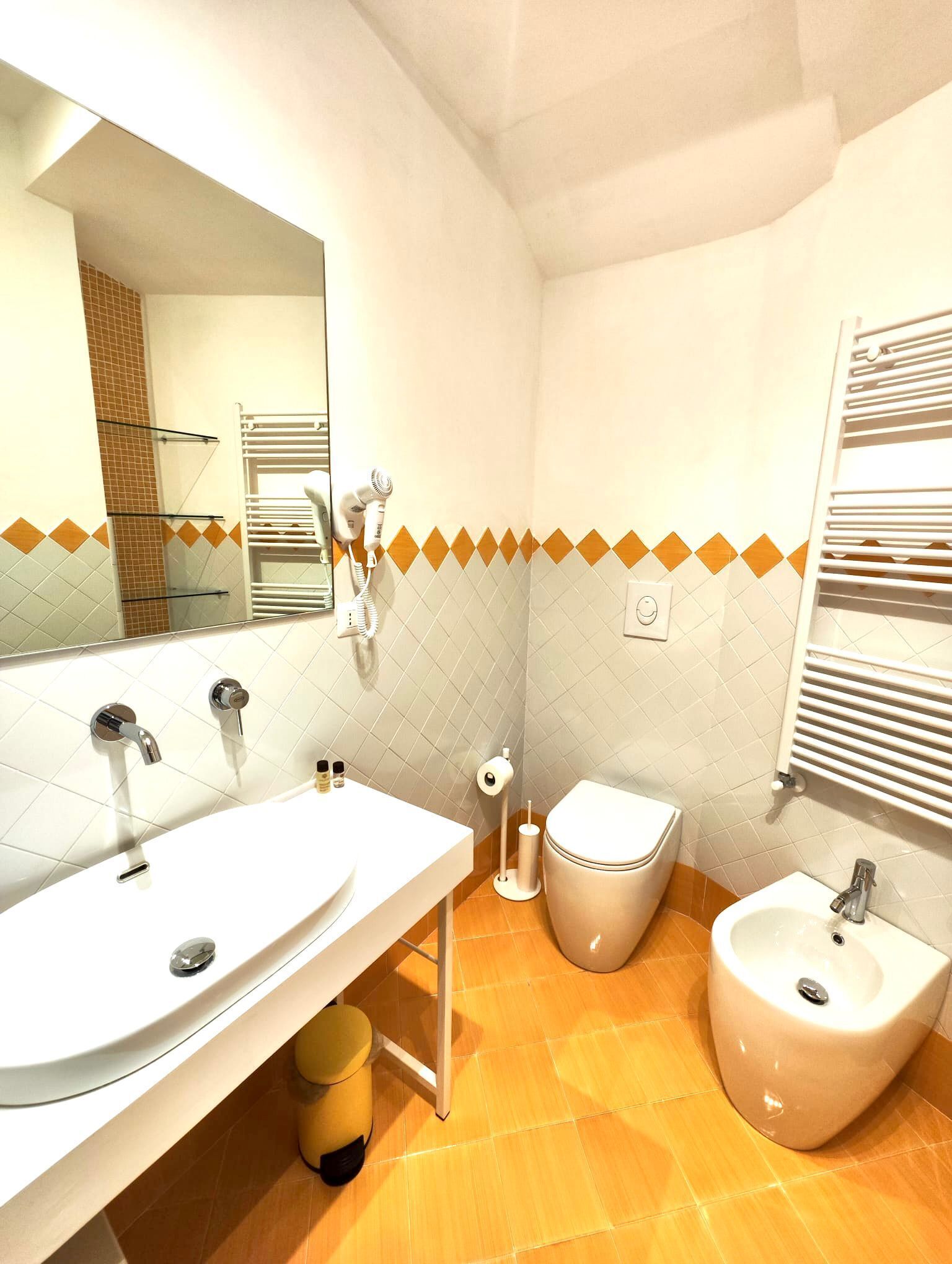 Un baño moderno con dos lavamanos, un inodoro y un bidé.