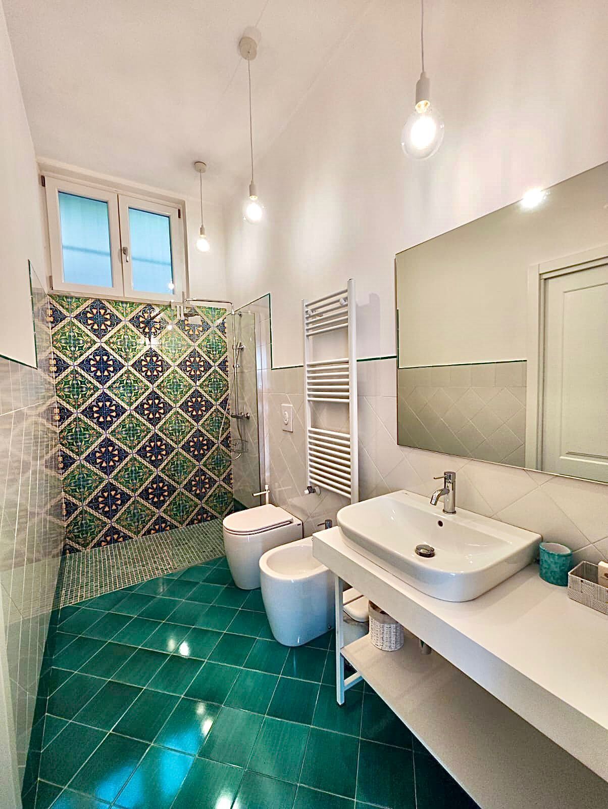 Une salle de bain moderne équipée d’une douche, de toilettes, d’un bidet et d’un lavabo.