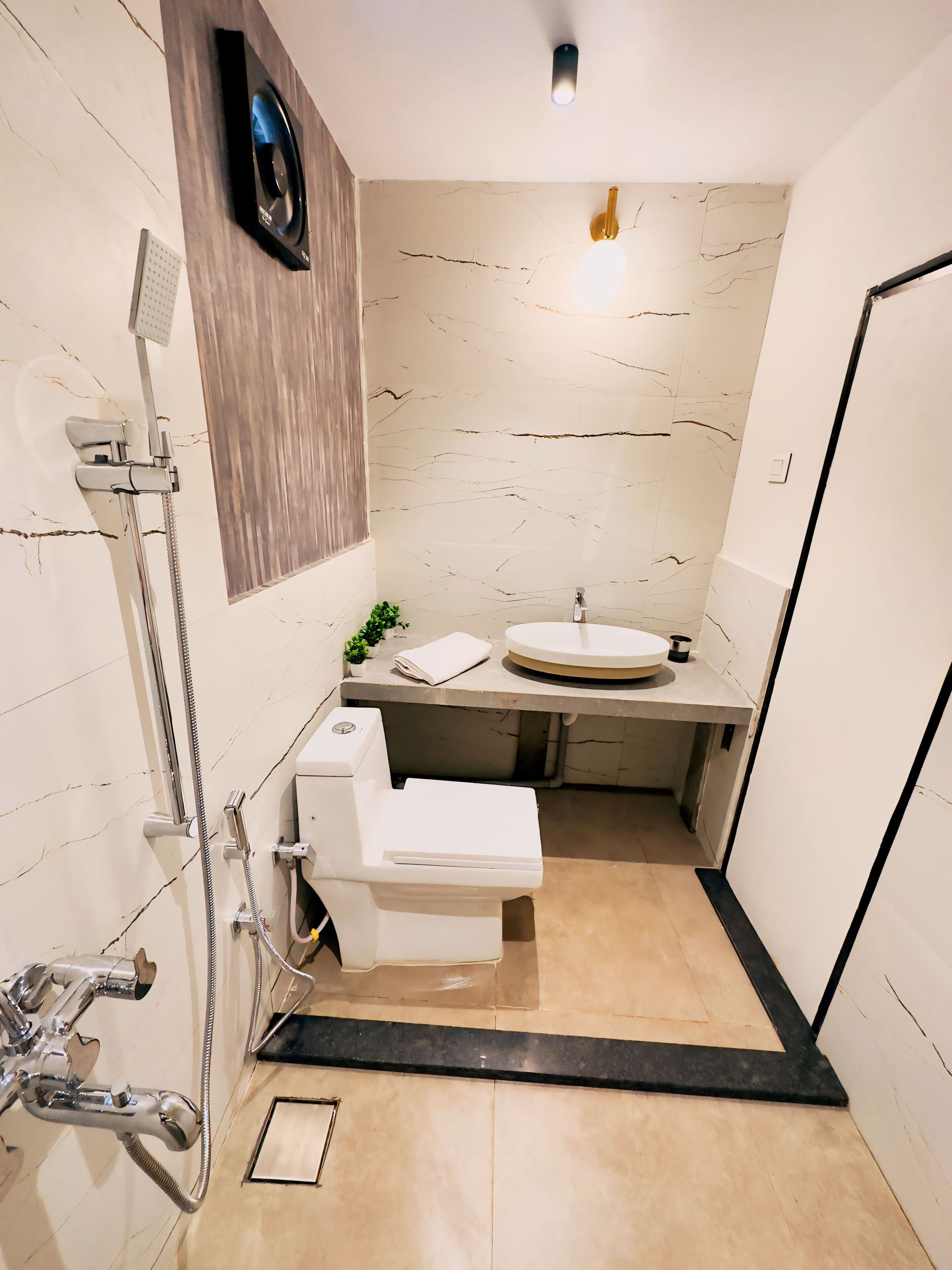 Une petite salle de bain comprenant une douche, des toilettes et un lavabo.