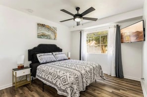 The bedroom is bright and cozy, with plenty of natural light, tasteful decorations, a ceiling fan, a double bed, nightstands with lamps, tv and a wardrobe. - Fairytale 2BR Orlando Home | Close to Disney Parks (Orlando)