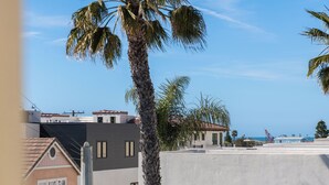Et boligområde med moderne bygninger, en palme og en klar, blå himmel.