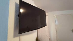 A flat-screen TV mounted on a white wall. - Room in Guest Room - Pension Forelle - Doppelzimmer (Forbach)