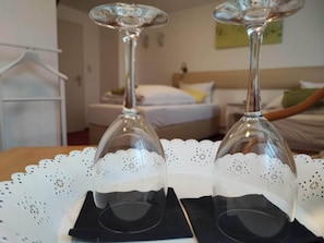 Two wine glasses on a tray with a doily, in a hotel room with a bed and a hanging coat rack. - Room in Guest Room - Pension Forelle - Doppelzimmer (Forbach)