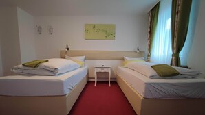 A hotel room with two single beds, a small bedside table, a nightstand, and a wall-mounted artwork. - Room in Guest Room - Pension Forelle - Doppelzimmer (Forbach)