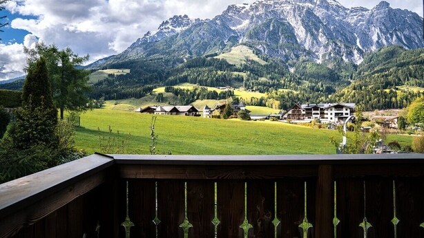 A mountain view with a wooden deck in the foreground. - Steinberghaus Top 3 (Rain)