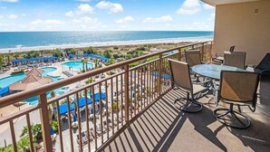 A balcony with a view of a beach and a pool area. - Relax in Style 3 Bdrm Condo with King and Queen (North Myrtle Beach)