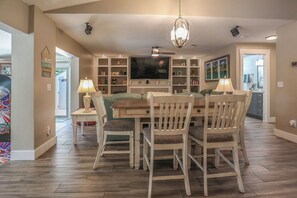 Ein geräumiges Wohnzimmer mit Essbereich, Fernseher und Kamin.