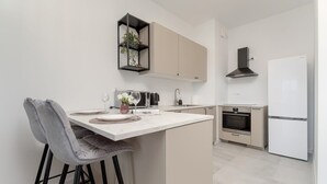 Eine moderne Küche mit einer zentralen Kochinsel, Barhocker, einer Mikrowelle, einem Herd und einem Kühlschrank.