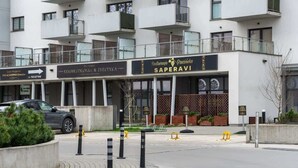Ein Gebäude mit einem Schild für das Restaurant 'Saperavi' und das Wellnesscenter 'Kosmetologia & Estetyk'.