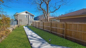 A residential property with a fenced backyard, a paved driveway, and a detached garage. - Luxury Studio, 3-Min Walk to Oaklawn Casino (Hot Springs)