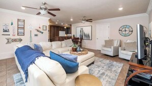 A living room with a sofa, chairs, a coffee table, and a television. - Lakeside Chalet w/Game Room & Private Boat Slip (Garland County)