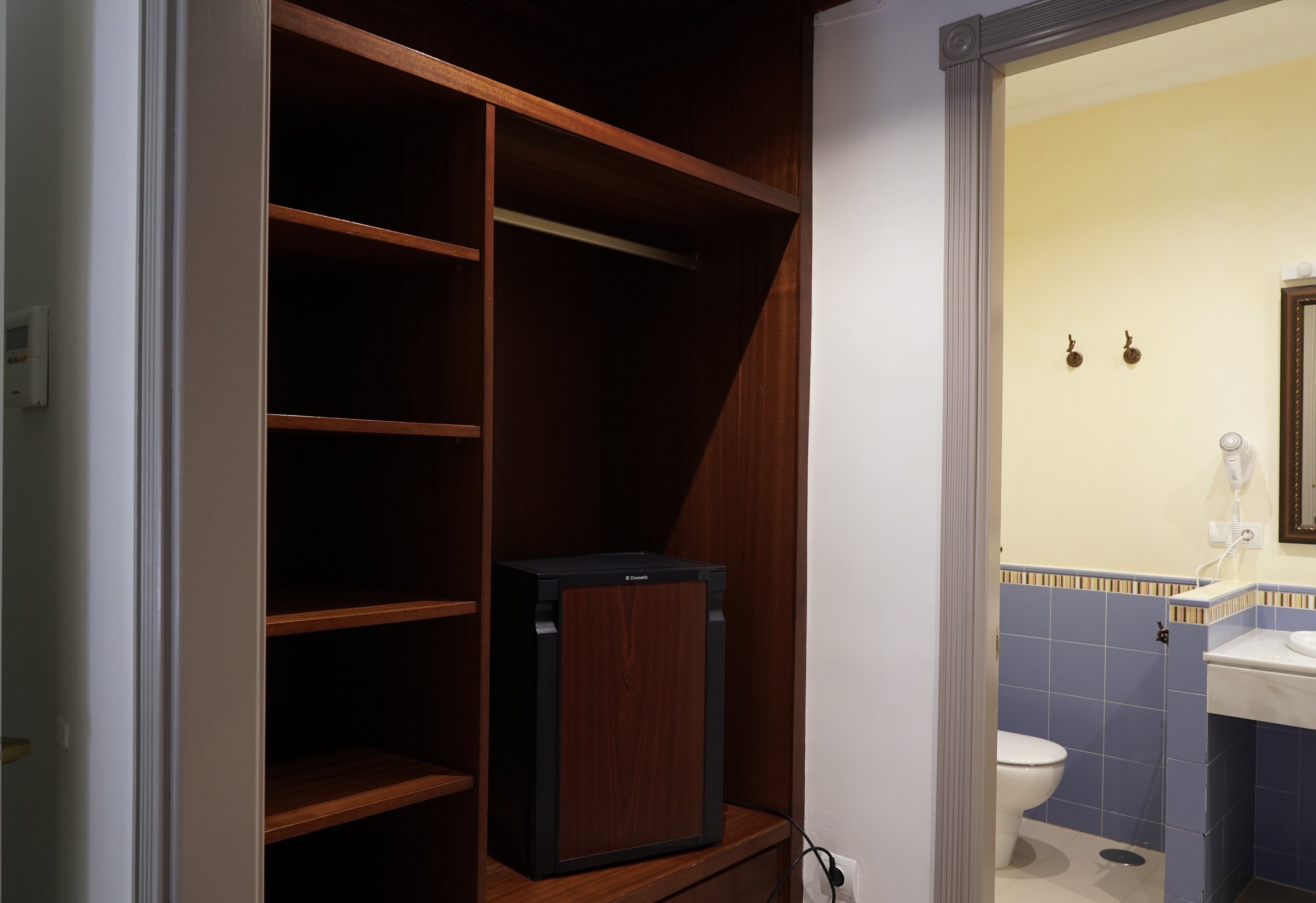 Een badkamer met toilet, wastafel en een houten kastje.