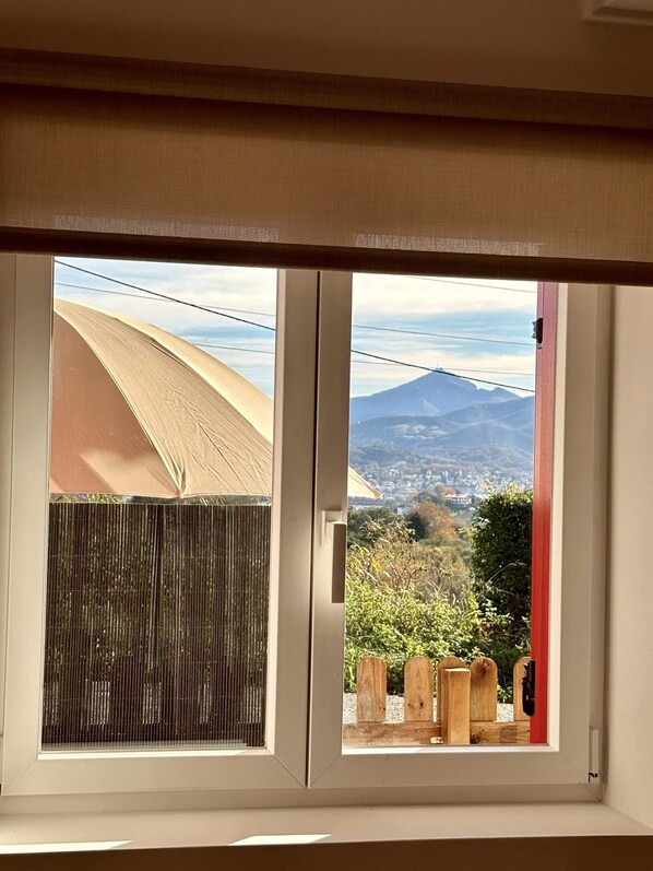 Ein Fenster mit Blick auf einen Berg und eine Stadt.