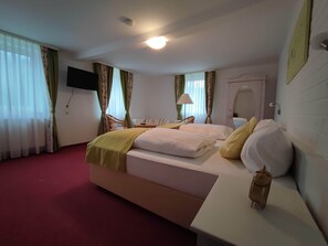 A hotel room with a bed, a desk, a chair, a TV mounted on the wall, and a window with curtains. - Room in Guest Room - Pension Forelle - Double Room No01 (Forbach)